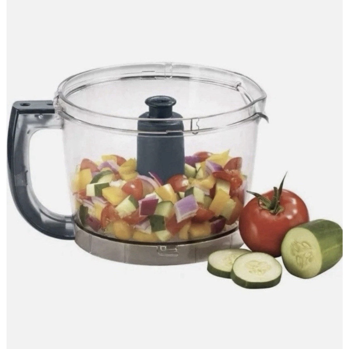 Catalog close-up of a food processor bowl with chopped vegetables, with tomato and cucumber alongside.